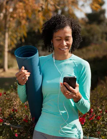 Woman on a mobile device with yoga equipment